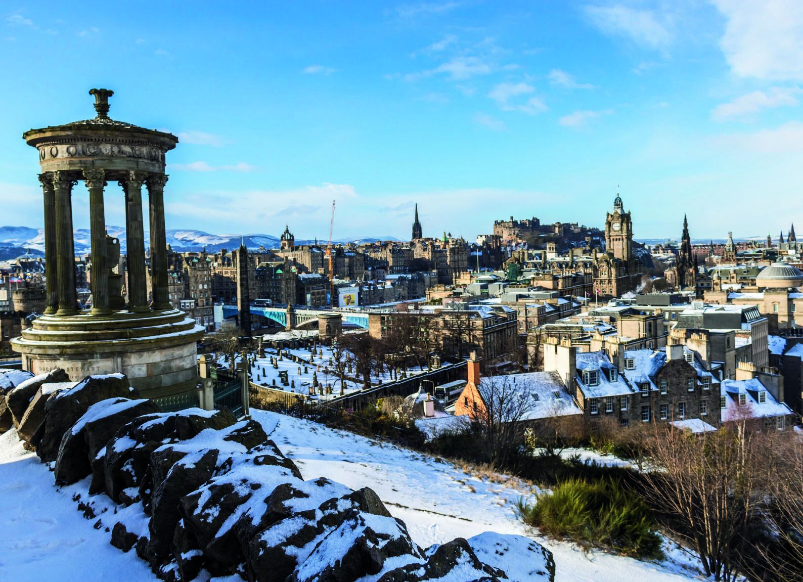 The view from Calton Hill across a snow-dusted Edinburgh, spires and rooftops fading into winter light