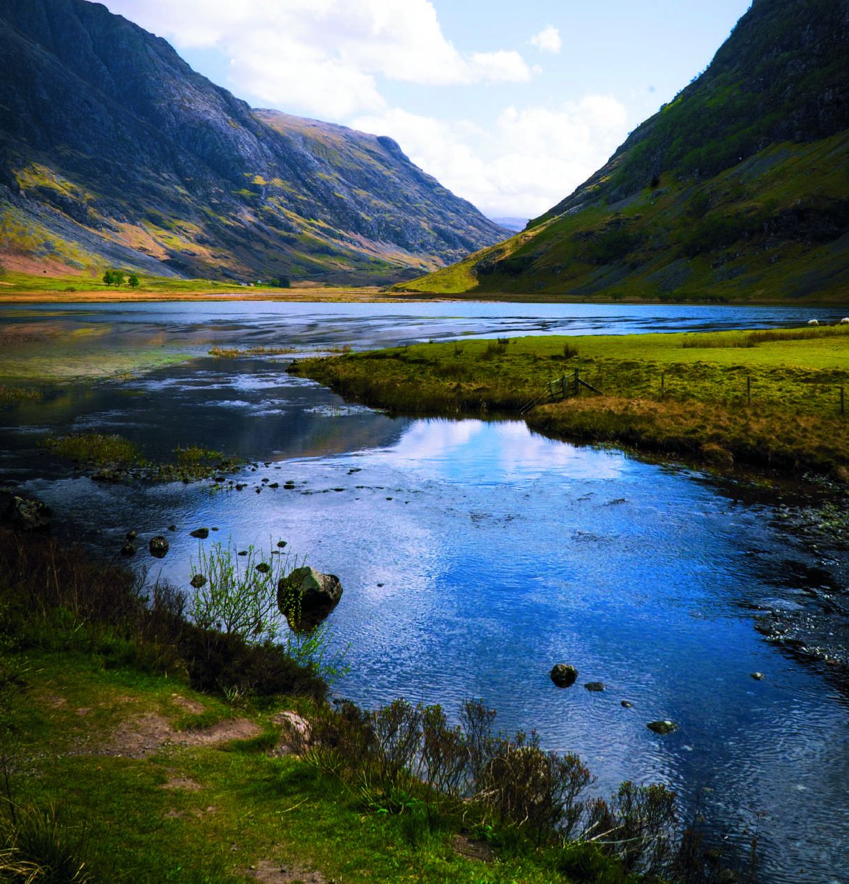 A Highland glen opening onto still water, mountains folding into the distance
