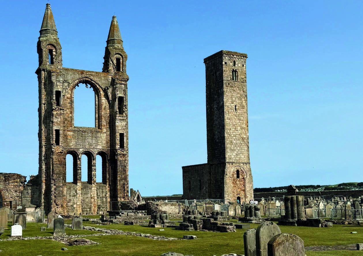 The ruined towers of St Andrews Cathedral rising over the old graveyard against a clear sky
